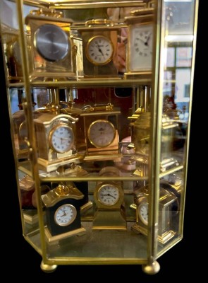 Auktion 356<br>kl. Sammlervitrine mit 9 kl. Quartz Uhren,  H-21 cm, B-14 cm, Uhren H-ca. 5-6 cm [1]
