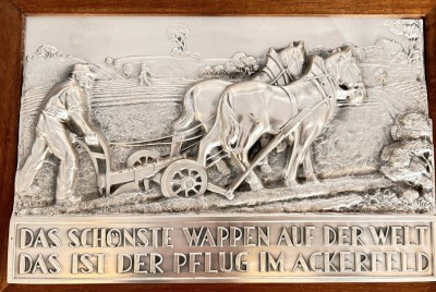 Auktion 357<br>Metall Wandbild mit pflügenden Bauern und Spruch, versilbert und Holzrahmen, RG 31x42 cm [1]