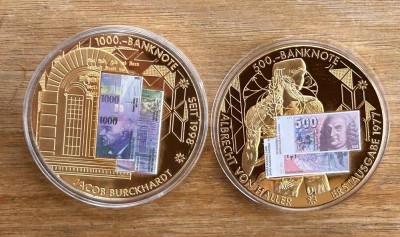 Auktion 358<br>2x gr. Medaillen  Schweizer Banknoten, D-5 cm, vergoldet,  boxed, 1x fehlt Deckel, [1]