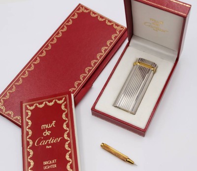 Auktion 359<br>Feuerzeug, Cartier, Trinity Serie, Godron, kl. Saphir, orig. Etui anbei Stelldrücker, leichte Gebryuchsspuren [1]