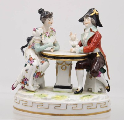 Auktion 359<br>Paar am Tisch, Neapel, bemalt, an Dame Schleife min. Chip, H-15cm B-15cm [1]