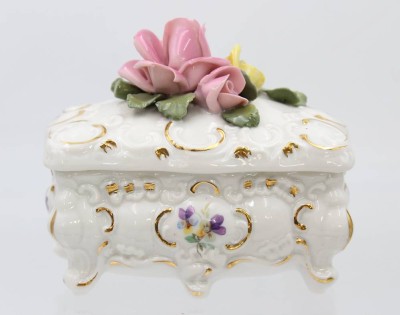 Auktion 359<br>Zierdose auf 4 Füssen, Dresden, aufgesetzte Rosenblüte (min. Chips), H-9,5cm B-11,5cm [1]