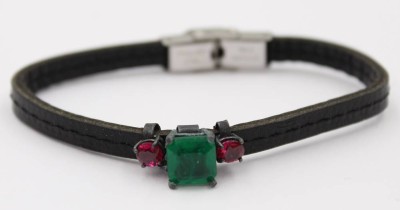 Auktion 361<br>Lederarmband mit einem Grünen erhitzten Smaragd  und 2 roten Steinen. [1]