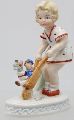 Auktion 363<br>Eine Mädchenfigur die einen Matrosen in einer Karre schiebt .  [1]