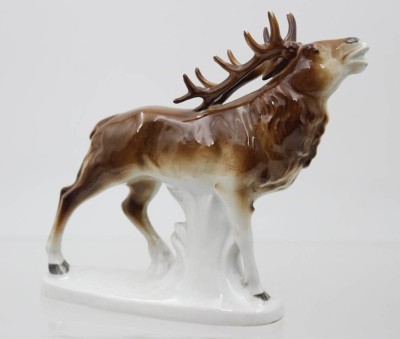 Auktion 368<br>röhrender Hirsch, ungemarkt, Unterglasurfarben, Geweih bestossen, ca. H-17cm [1]