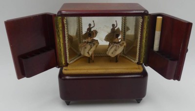 Auktion 363<br>Spieluhr in Form eines 30/50-er J. Schrankes als Zigarettenhalter, mit 2 Tänzerinnen, Werk läuft, H-17 cm, 16x8 cm [1]