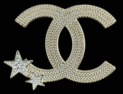 Auktion 363<br>Coco Chanel Brosche um 1940/40  mit Sternen, klare Steine und vergoldet, verso gemarkt Chanel A21-Made in France, H-6 cm [1]