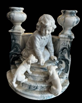 Auktion 364<br>Figurengruppe, Junge mit Hundewelpen, auf Treppe mit beidseitig Kerzenhalter?1x Rand mit Chip, 15x15 cm [1]