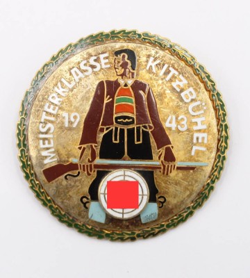 Auktion 365<br>Farbig emailliertes Teilnehmer-Abzeichen 1943, (Ges. Gesch.) Meisterklasse Kitzbühel, Schütze von vorn, davor Zielscheibe mit HK. Rs., 53 mm [1]