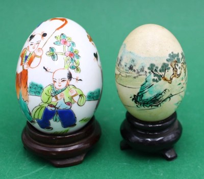 Auktion 365<br>2x handbemalte chinesische Eier, auf Holzstand, 1x echte Eierschale H- 6cm, 1x Porzellan-Ei H- 8cm (Höhe je ohne Stand) [1]