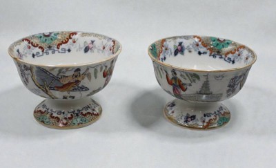 Auktion 366<br>Paar Fusschalen, Regout, Petrus. Maastricht 1836 - 1899, Timor, bedruckt, von Hand ausgemalte Chinoiserien, Altersspuren,  1x Altriss, ca. H-11cm D-16cm und 10,5cm D-15,5cm [1]