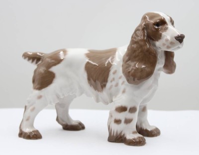 Auktion 367<br>Cockerspaniel, Bing & Gröndahl, Modellnr. 2095, Entwurf Laurits Jensen, naturalistisch staffiert in Unterglasurfarben, ca. H-16,5cm, L-20,5cm [1]