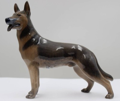 Auktion 367<br>Deutscher Schäferhund, Royal Copenhagen, Entw. Th. Madsen, Modellnr. 3261, naturalistisch staffiert in Unterglasurfarben, an Zunge kleiner Chip, L- ca. 23cm  H-16cm [1]