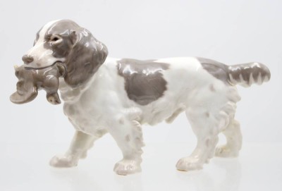 Auktion 367<br>Bing & Gröndahl, Porzellanfigur, Cockerspaniel mit Fang, Modellnr. 2061, Entw. Laurits Jensen, H-14,5cm L-25cm, leider in Bein restauriert [1]