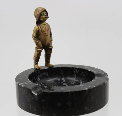 Auktion 368<br>Aschenbecher aus schwarzem Marmor mit einer Bronzefigur eines kleinen Jungen, um 1920/30, Adcher mit einigen kl. Abplatzern, ca. H-14cm D-14cm [1]