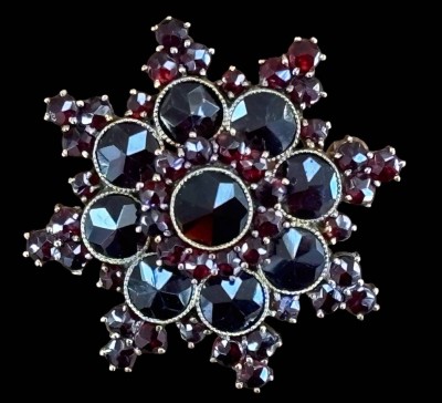 Auktion 368<br>Sternbrosche, Granat mit Normgold-250-, Norm gemarkt, D-3,3 cm, 13 gr [1]