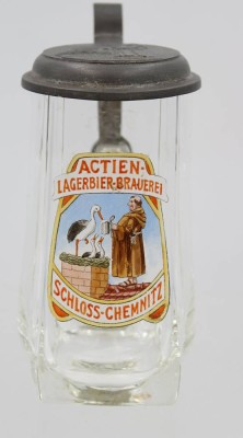 Auktion 369<br>Jugendstil Glaskrug der  Actien-Lagerbier-Brauerei Schloss-Chemnitz. Zinndeckel ebenfalls mit Wappen, 0,35 L, rückseitig unter Henkel Riss und Absplitterung, H-16 cm [1]