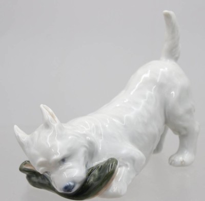 Auktion 370<br>West Highland White Terrier mit einem Schuh spielend, Royal Copenhagen, 20. Jhd., Modelnr. 3476, ca. H-9cm L-11,5cm, ein Schleifstrich [1]