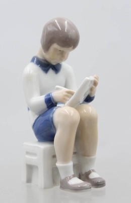Auktion 370<br>schreibender Junge, Bing & Gröndahl, Copenhagen, Mod.Nr. 2184, Unterglasurbemalung, H-12,5cm, Kopf geklebt. [1]