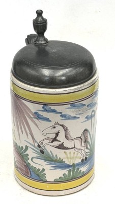 Auktion 371<br>Fayence Walzenkrug um 1770, springendes Pferd mit Zinndeck, Meistermarke datiert 1747 , Boden mit Altrissen, H-22 cm, D-11 cm [1]