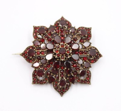 Auktion 372<br>Granat-Sternbrosche, wohl Tombak, ca. D-3,8cm [1]