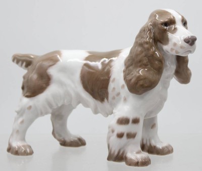 Auktion 372<br>Cockerspaniel, Bing und Gröndahl, Modellnr. 2095, Entwurf Laurits Jensen, naturalistisch staffiert in Unterglasurfarben, ca. H-15,5cm, L-21,5cm [1]
