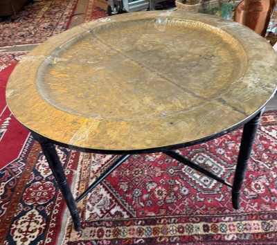 Auktion 372<br>Chines. Tisch mit grosser, runder Messingplatte, graviert mit Drachendekor am Rand und mittig, Rest mit Blütengravur, klappbares Holzgestell (diese leicht restaurierungsbedürftig, Altersspuren, mittig Lötnaht, H-50 cm, D-90 cm [1]