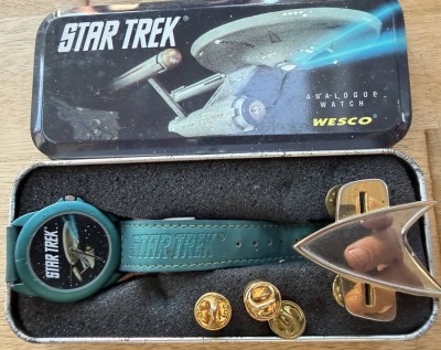 Auktion 372<br>Star Trek Armbanduhr von Wesco aus den 1990er Jahre in orig. Blechdose mit Komunikator Abzeichen und 3 Knöpfe, Quartz, Altersspuren [1]