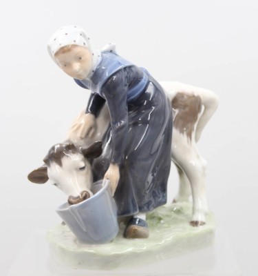 Auktion 373<br>Mädchen, das ein Kalb aus einem Eimer füttert, Royal Copenhagen, Entw. Christian Thomsen, Modellnr. 779, H-16cm, L-17cm, ein Schleifstrich [1]